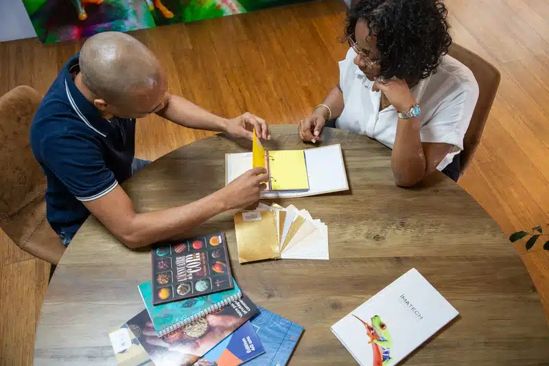 Two people discussing color samples at a table.