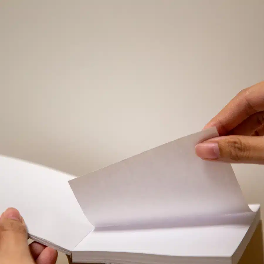 Hands flipping pages of a notebook