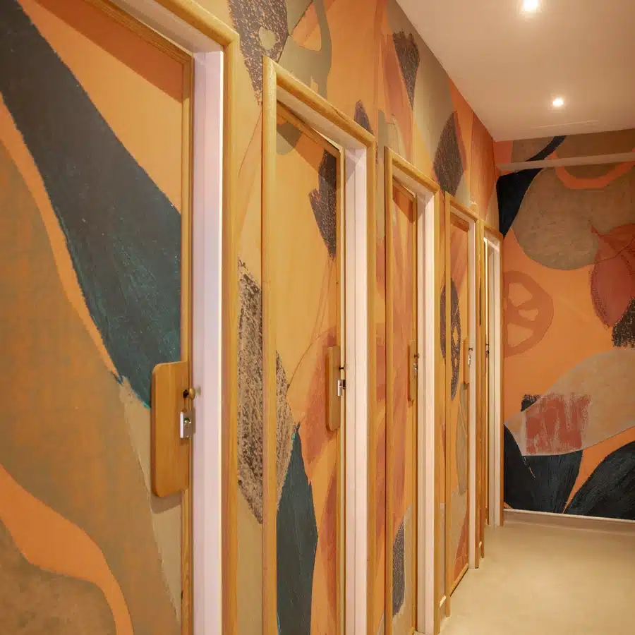 Room with abstract mural and wooden doors hallway.